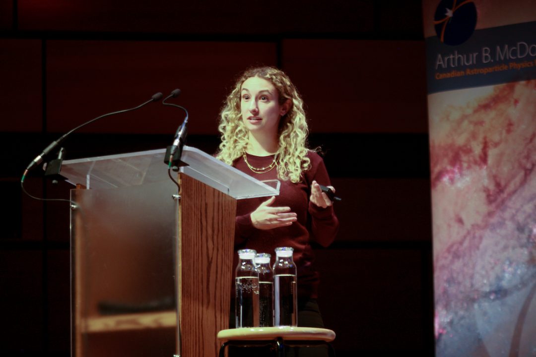 Liz Favot speaks into a microphone while standing at a podium.