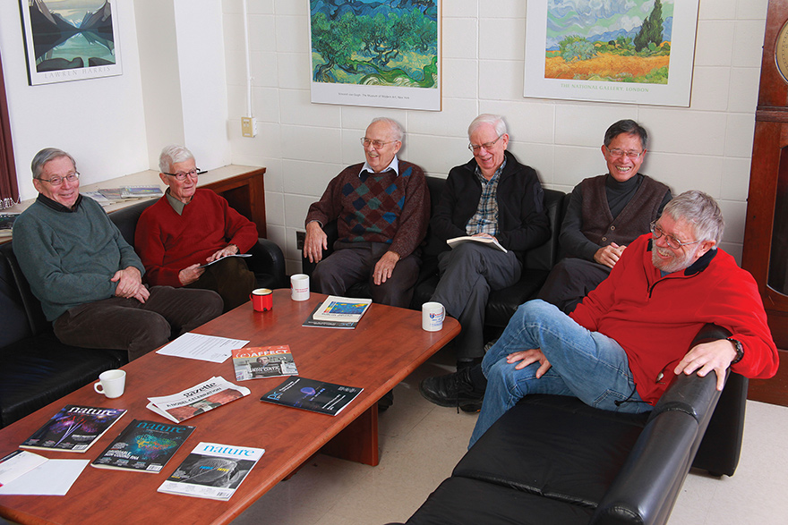 Barry Robertson, Hugh Evans, George Ewan, Hamish Leslie, Hay Boon Mak and Peter Skensved sit on couches in a circle, talking and laughing