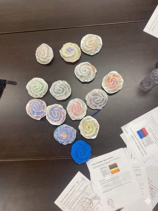 Classroom galaxy craft models displayed with worksheets.