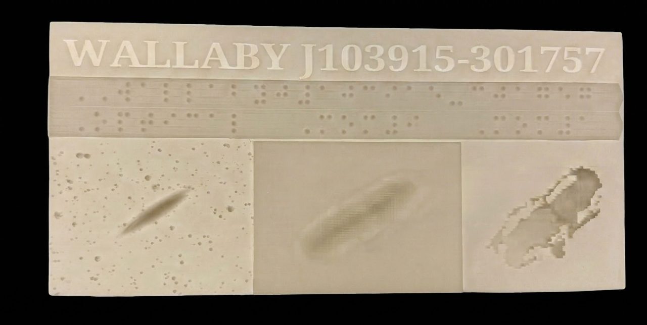 Tactile galaxy panel with braille and three raised sections showing optical, density, and velocity data.